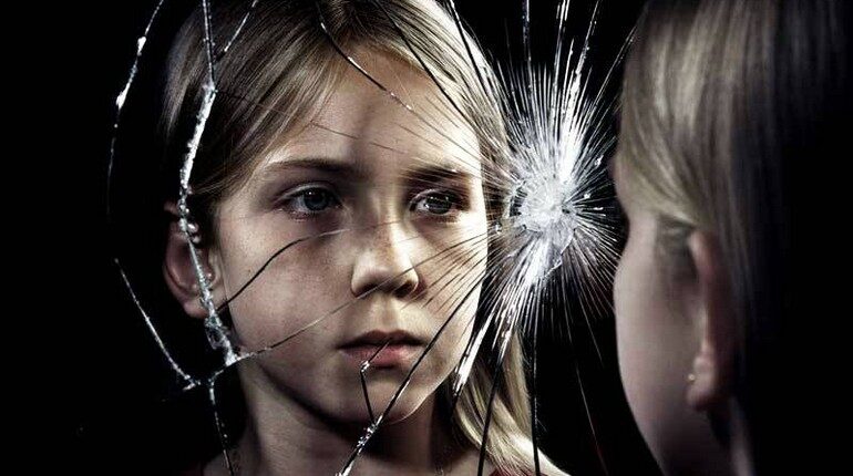 девочка смотрит в разбитое зеркало, треснутое зеркало и отражение девочки