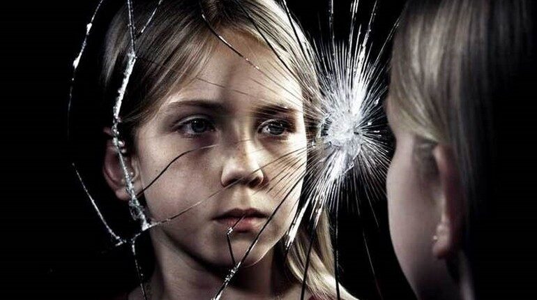 девочка смотрит в разбитое зеркало