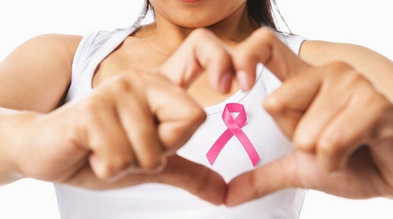 девушка против рака груди, у девушки на груди бантик символ борьбы с раком груди