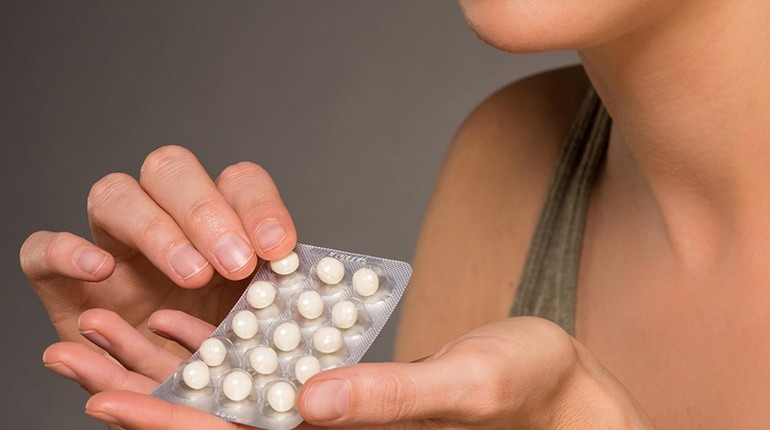 девушка держит пластинку таблеток в руке, прием гормональных препаратов, гормоны и здоровье
