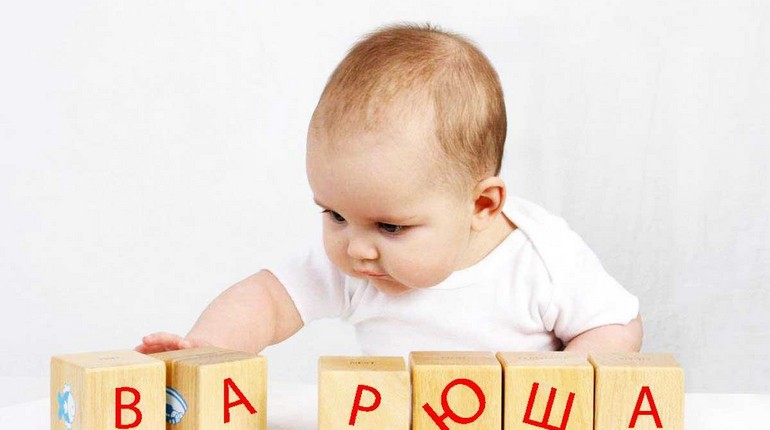 малышка играет кубиками, младенец складывает кубики