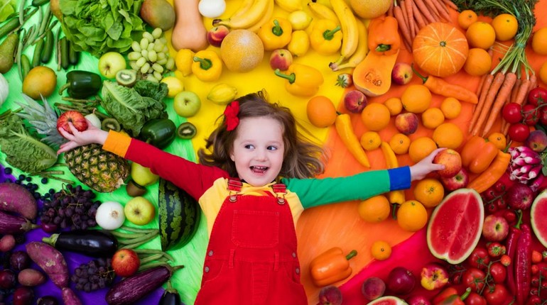 ребенок на фоне витаминов, девочка на фоне фруктов и овощей