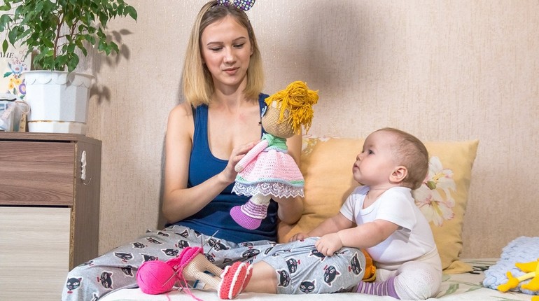 девушка делает руками игрушки и малыш смотрит на маму