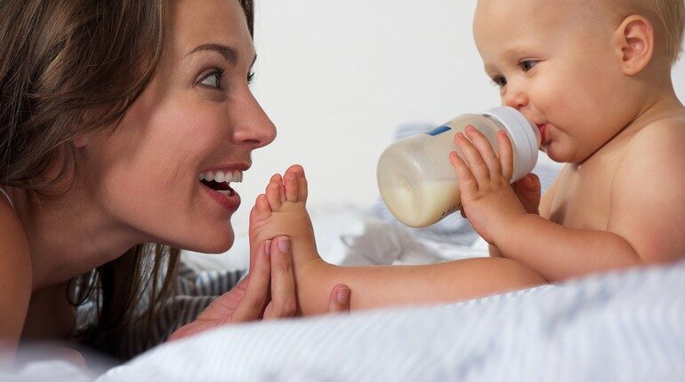 малыш кушает из бутылочки, мама с малышом