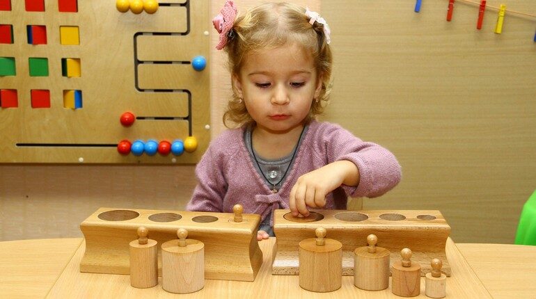 девочка играет деревянными игрушками, игрушки по методике монтессори