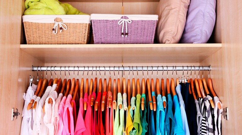 идеальный порядок в шкафу, вещи развешены по цветам, все сложено аккуратно в шкафу