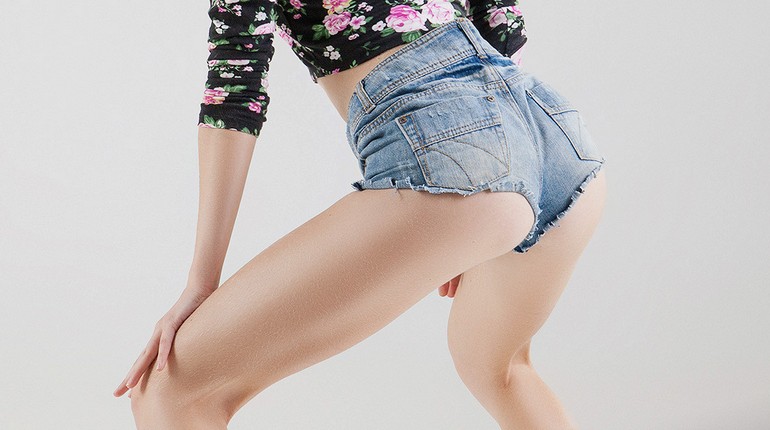 девушка танцует тверк в коротких шортиках, женские ягодицы в джинсовых шортиках