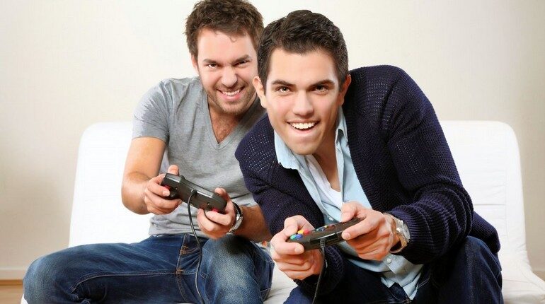 два парня играют в видеоигру, парни с джостиками играют в приставку