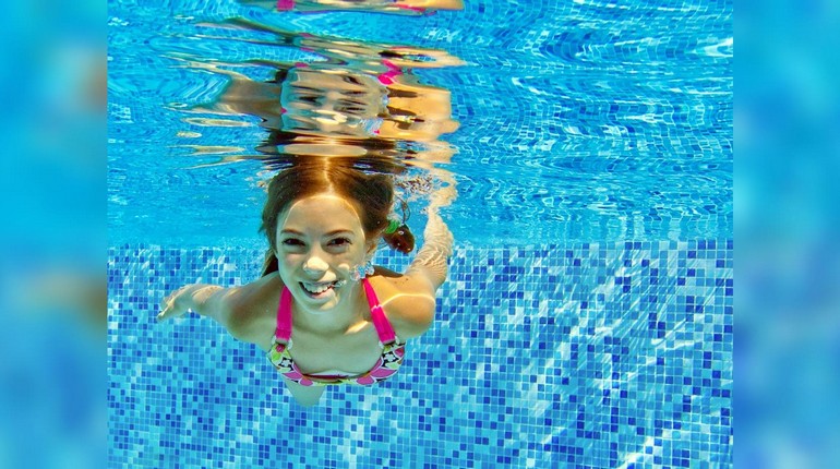 девушка плавает в бассейне